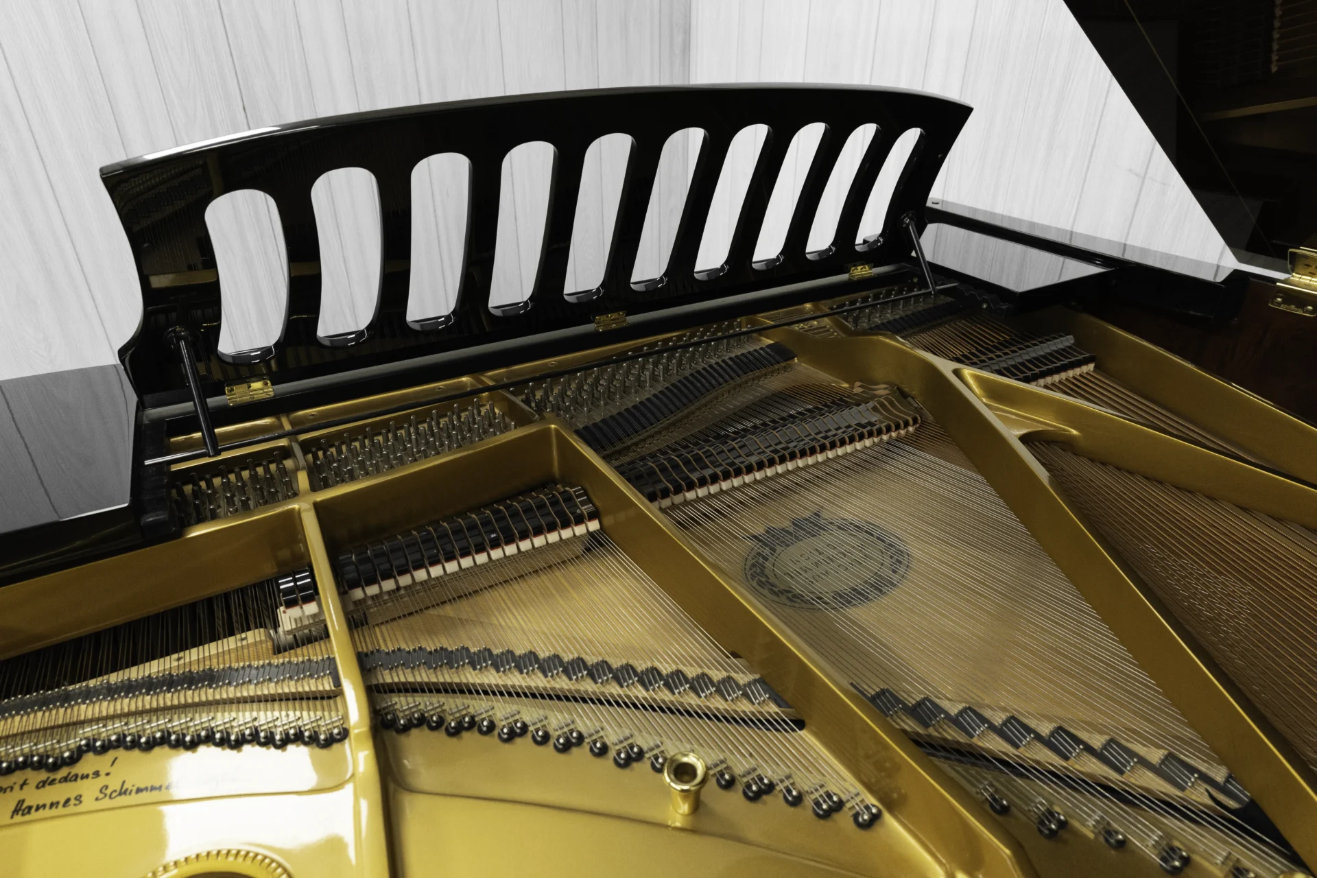 the inside of a Schimmel Meisterstücke NWS Edition Grand Piano, showing off the beautifully maintained harp, strings, dampers, and soundboard