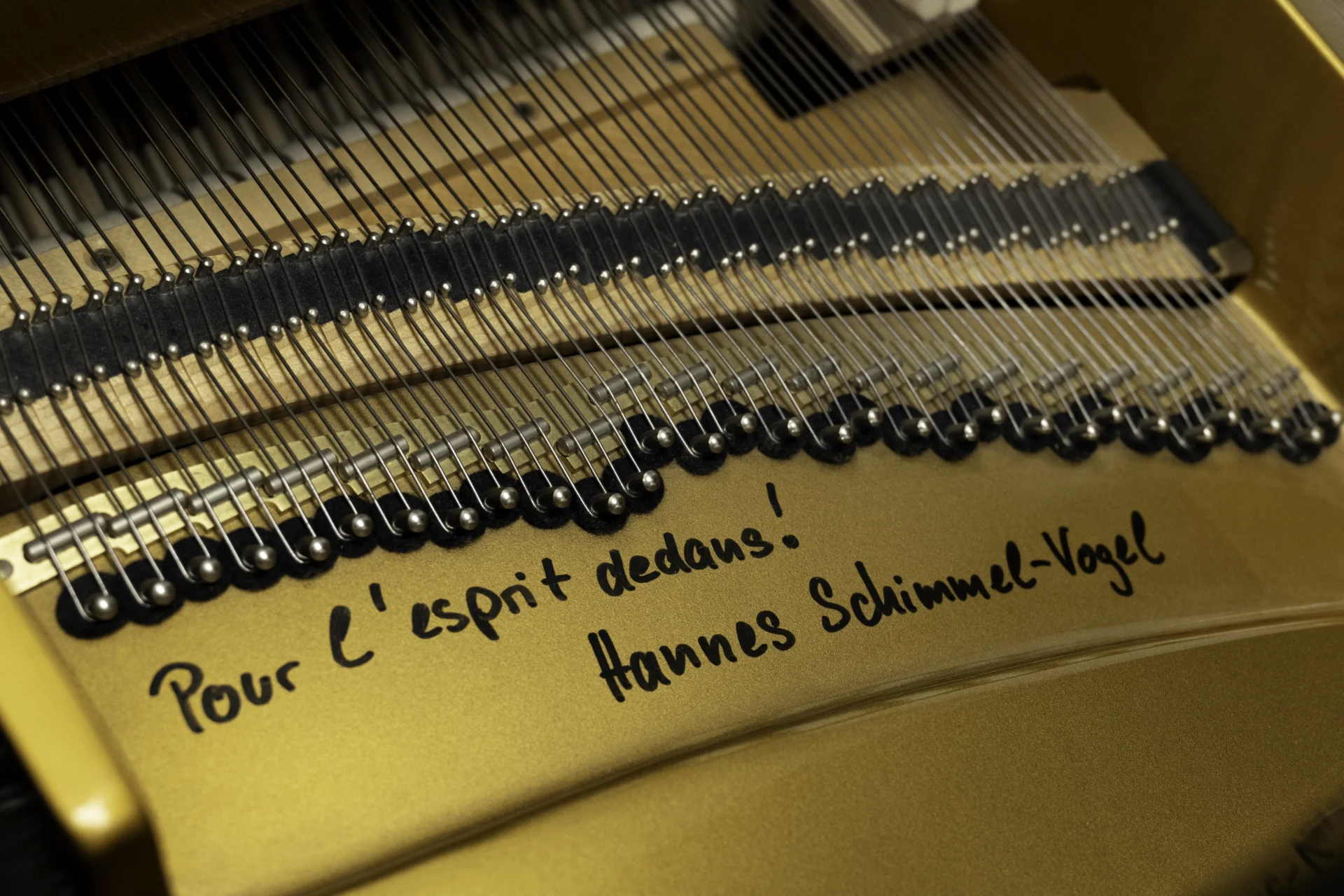 a close up of the signature of Hannes Schimmel-Vogel, present on the harp of this beautiful Schimmel Meisterstücke NWS Edition Grand Piano.