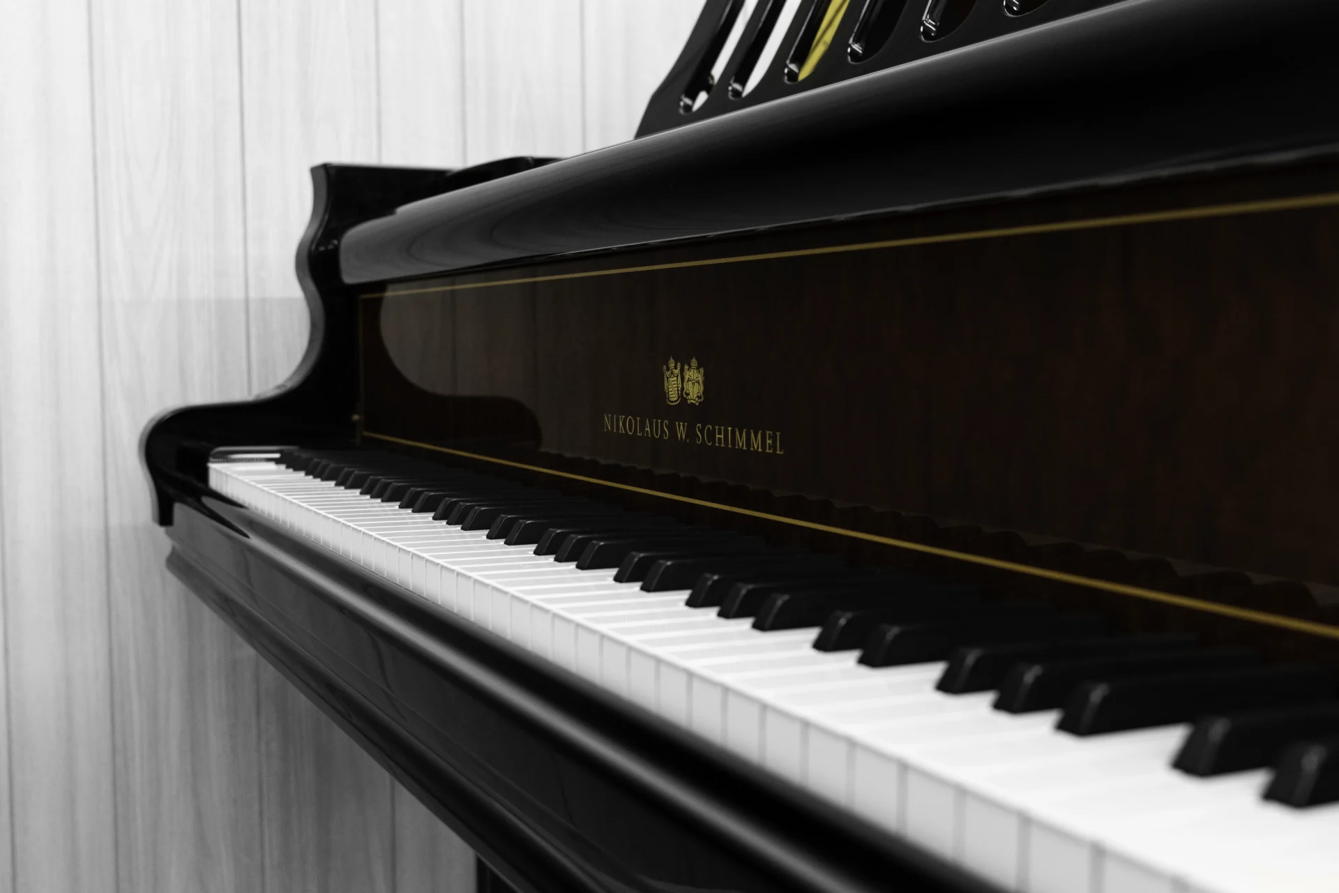a close up on the keys and fallboard of this beautiful Schimmel Meisterstücke NWS Edition Grand Piano, showing off the stunning polished ebony and mahogany finish as well as the gold trim and Schimmel logo present on the fallboard.
