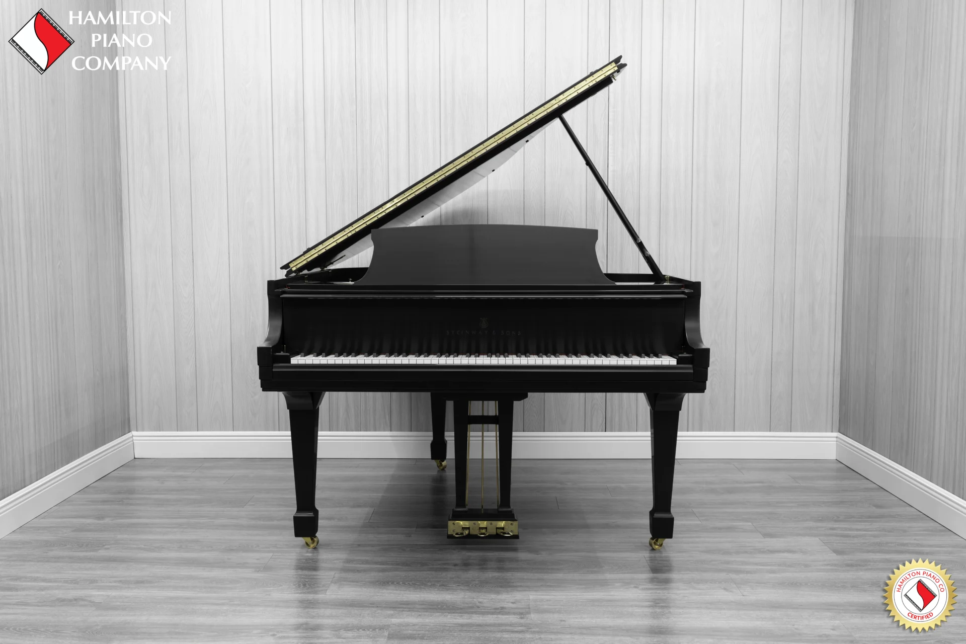 A Steinway M baby grand piano in a beautiful satin ebony finish with brass hardware.