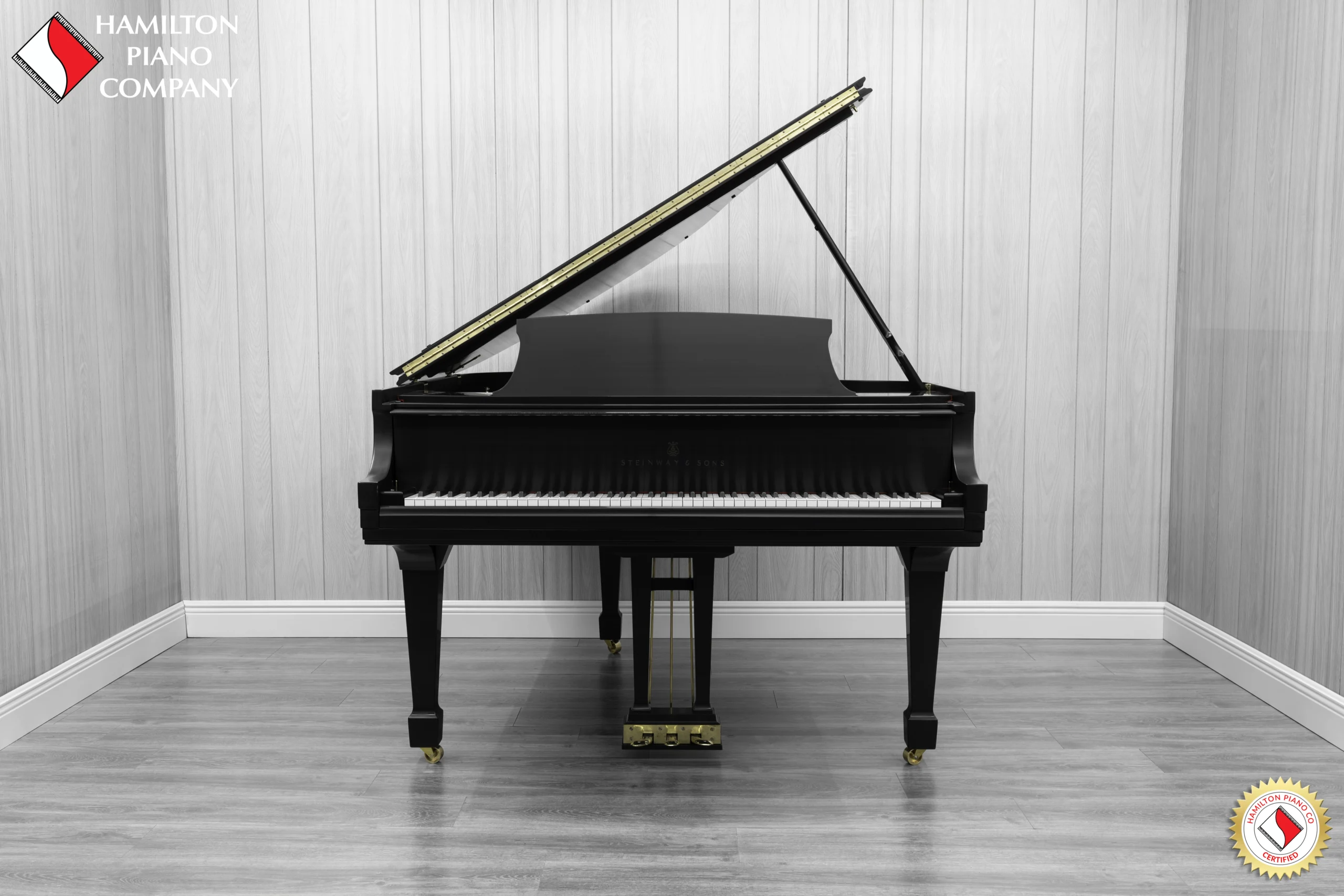 A Steinway M baby grand piano in a beautiful satin ebony finish with brass hardware.