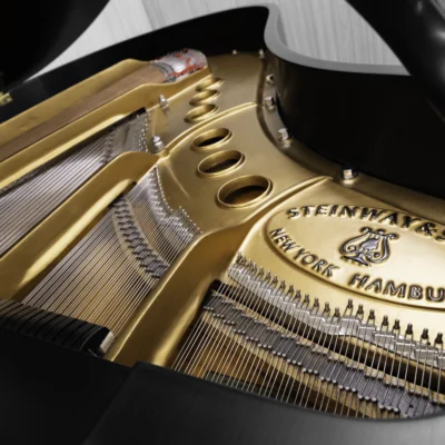 A Steinway M baby grand piano in a beautiful satin ebony finish with brass hardware and a bench. The image shows off the interior of the piano including the harp and strings.