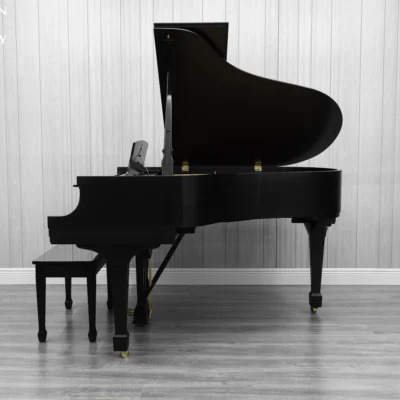 A Steinway M baby grand piano in a beautiful satin ebony finish with brass hardware and a bench.