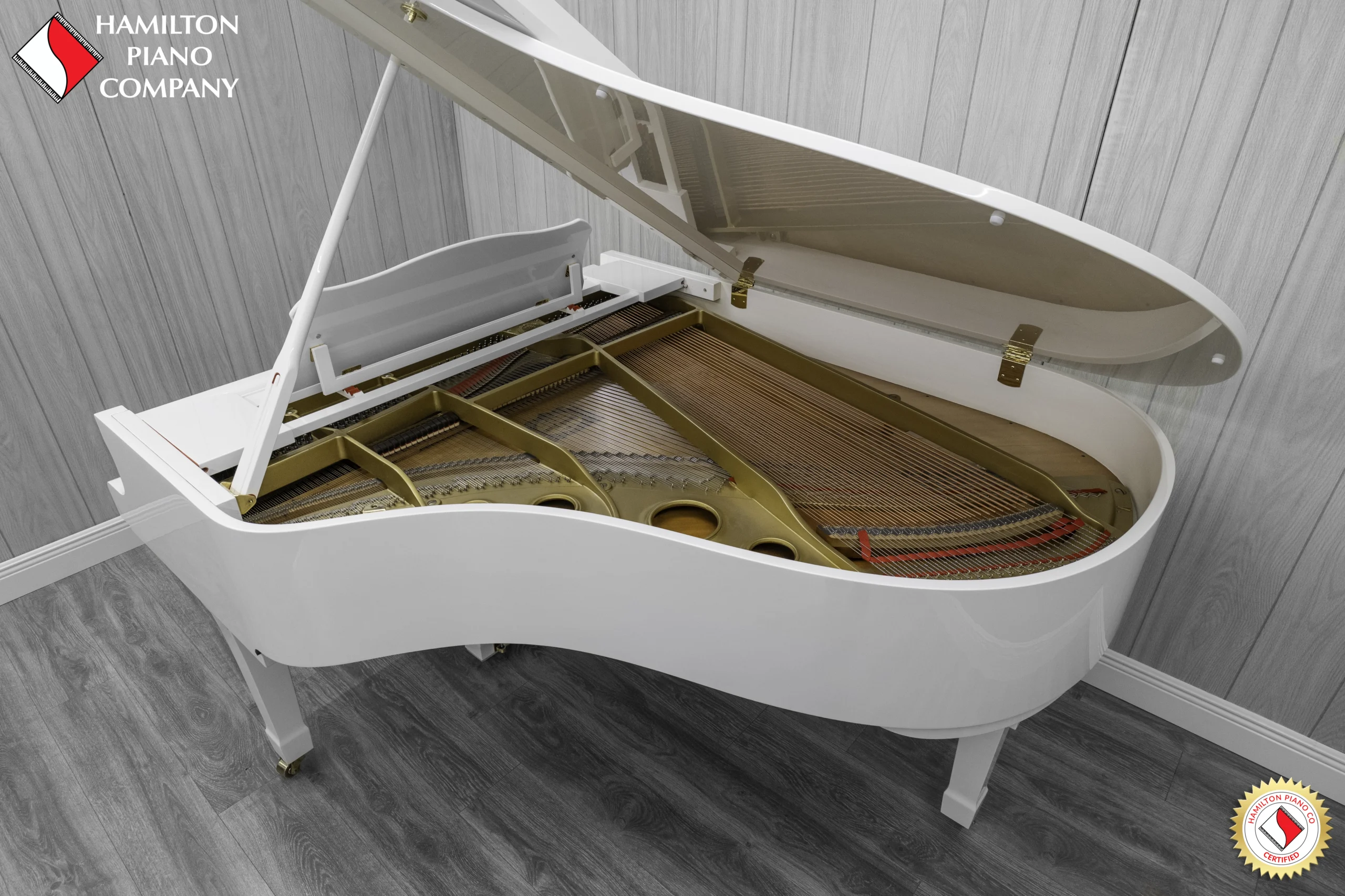 A 1980 Yamaha G3 Grand Piano in a high polish white finish. The image shows of the interior of the piano, including the harp and strings.