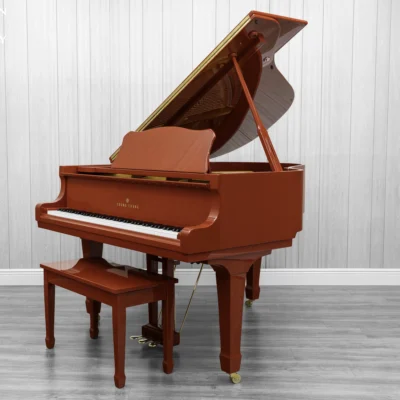 A Young Chang G-157 baby grand piano in a high polish red finish with matching bench.