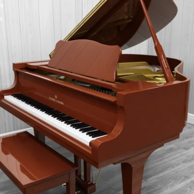 A Young Chang G-157 baby grand piano in a high polish red finish with matching bench.