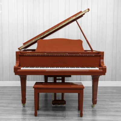 A Young Chang G-157 baby grand piano in a high polish red finish with matching bench.