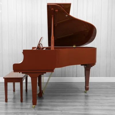A Young Chang G-157 baby grand piano in a high polish red finish with matching bench.