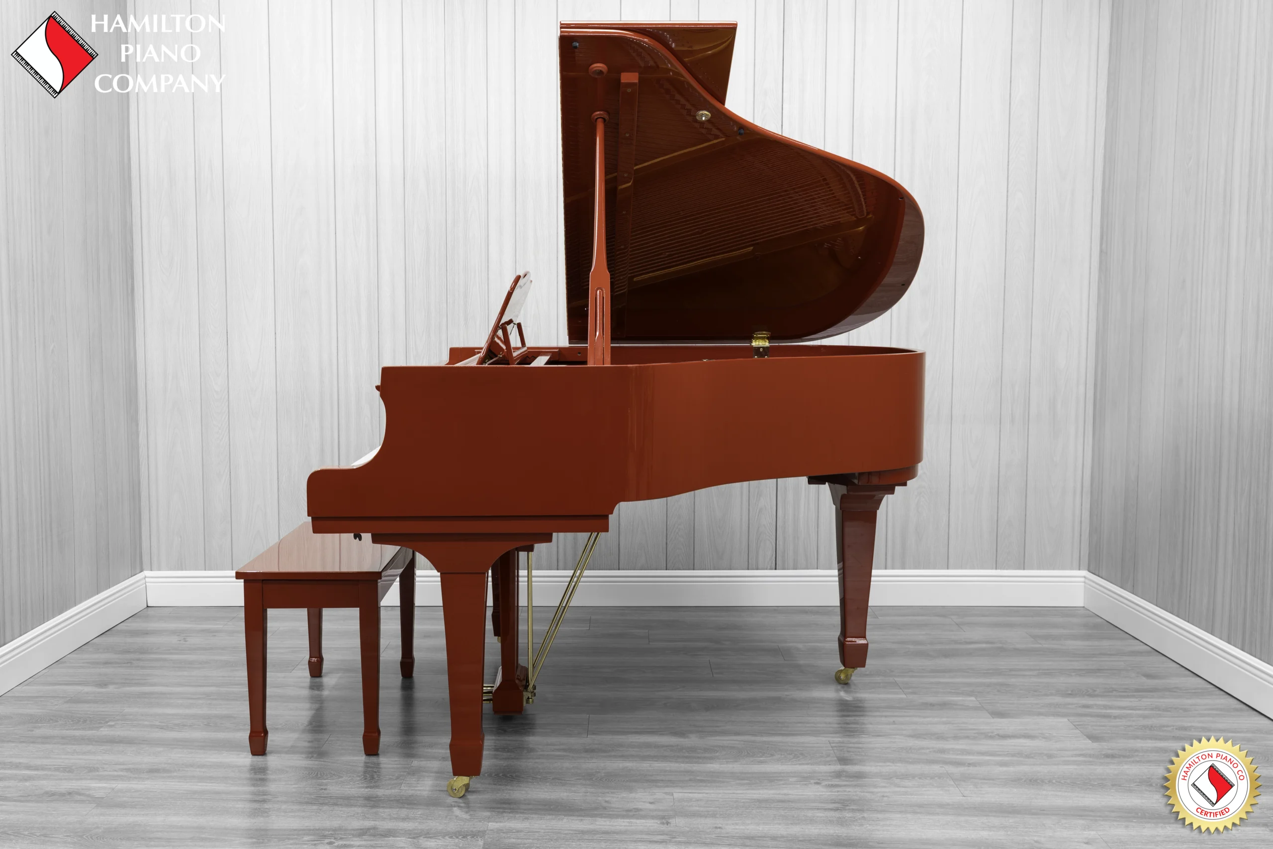 A Young Chang G-157 baby grand piano in a high polish red finish with matching bench.