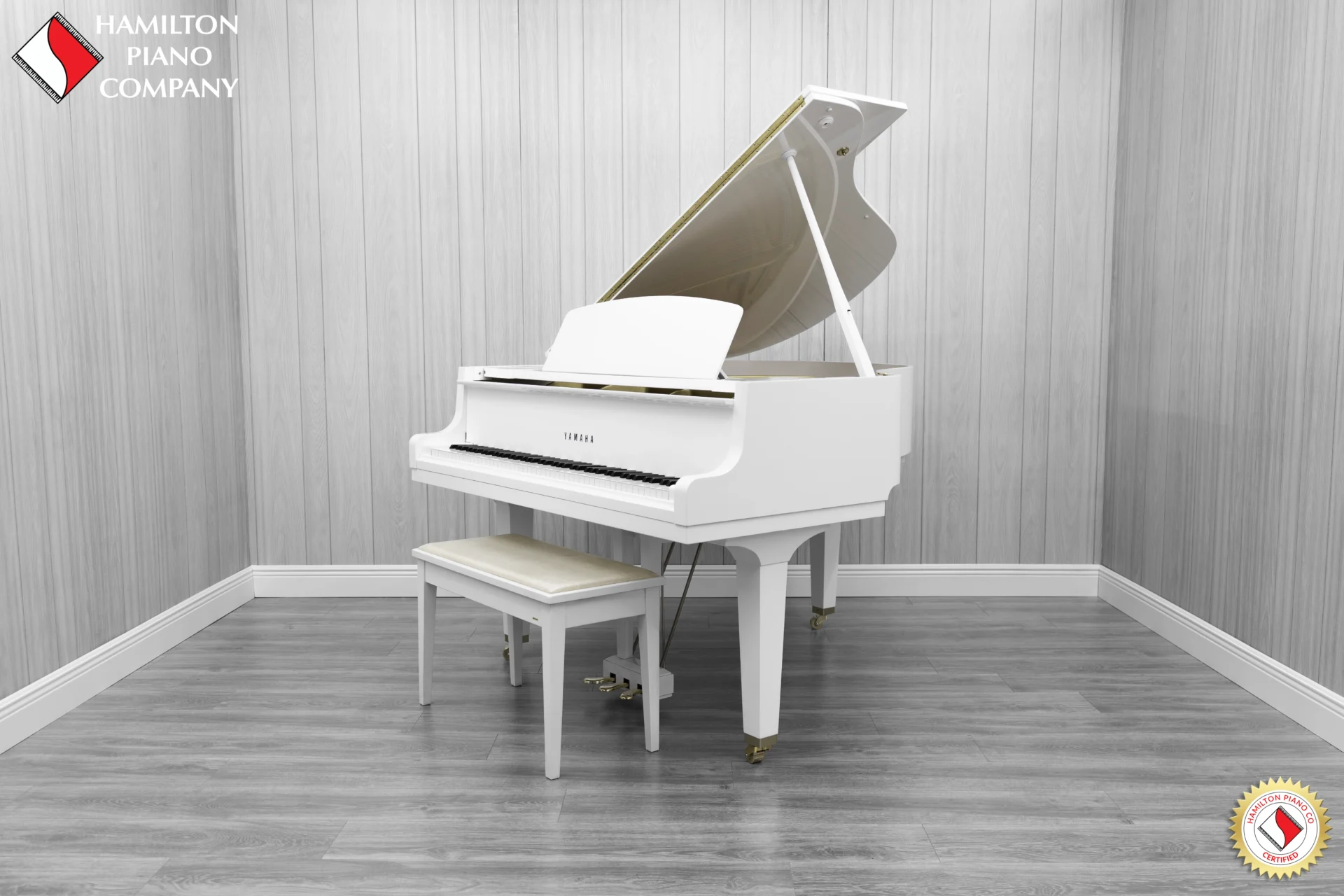 A Yamaha GH1 baby grand piano in a high polish white finish