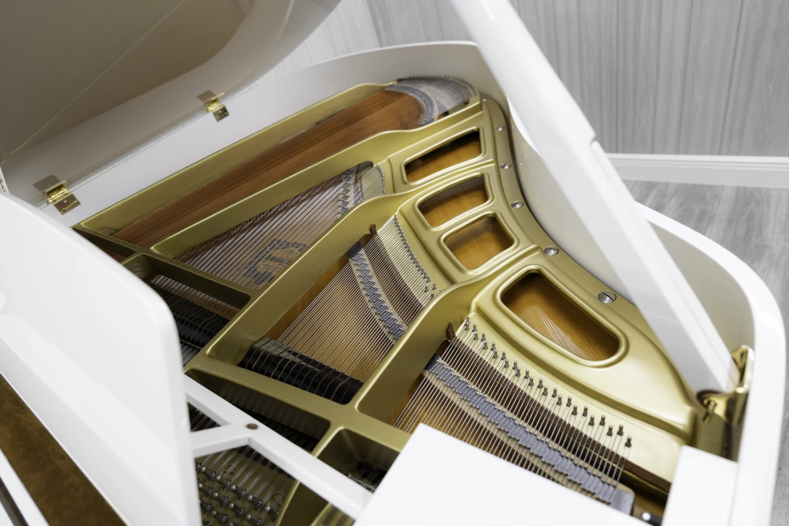 A Yamaha GH1 baby grand piano in a high polish white finish