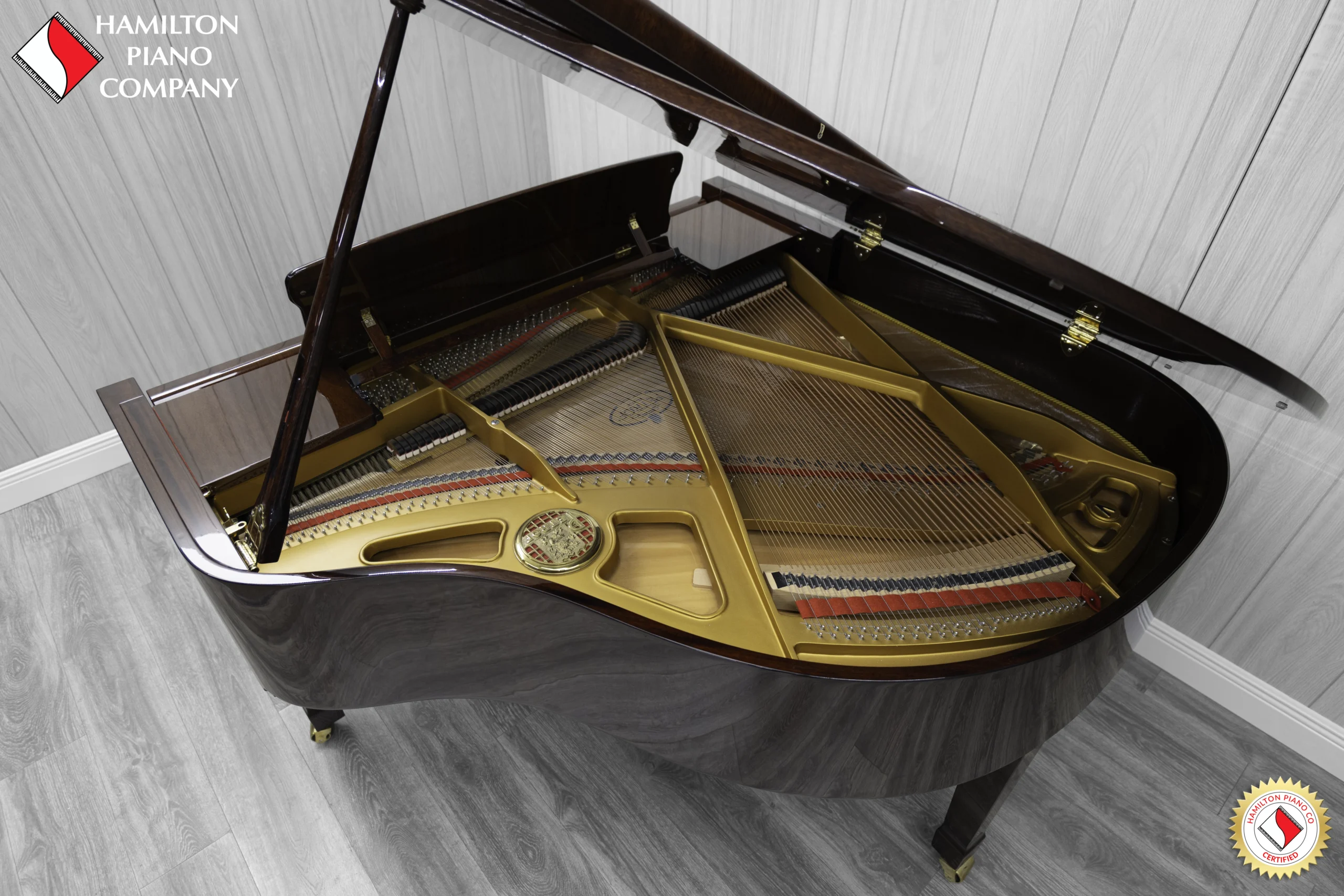 Petrof baby grand piano in high polish mahogany finish with a good view of the interior including the harp and strings