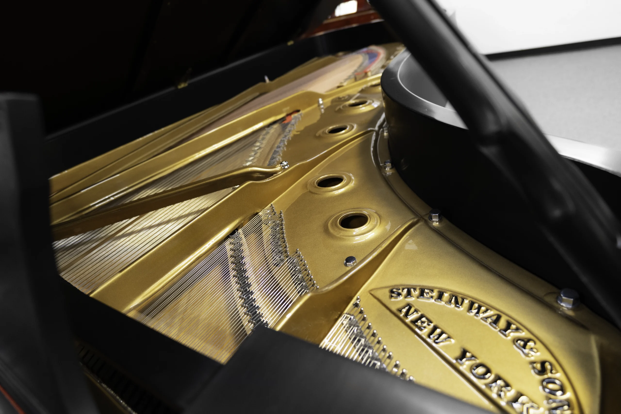 A 9ft Steinway D Concert Grand Piano in hand-rubbed satin ebony finish. An internal shot focusing on the piano harp and strings.