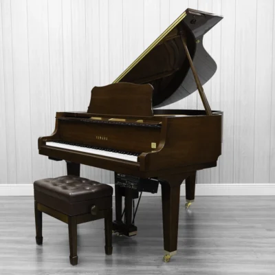 A pre-owned Yamaha GH1 baby grand piano in a beautiful mahogany finish with brass hardware.