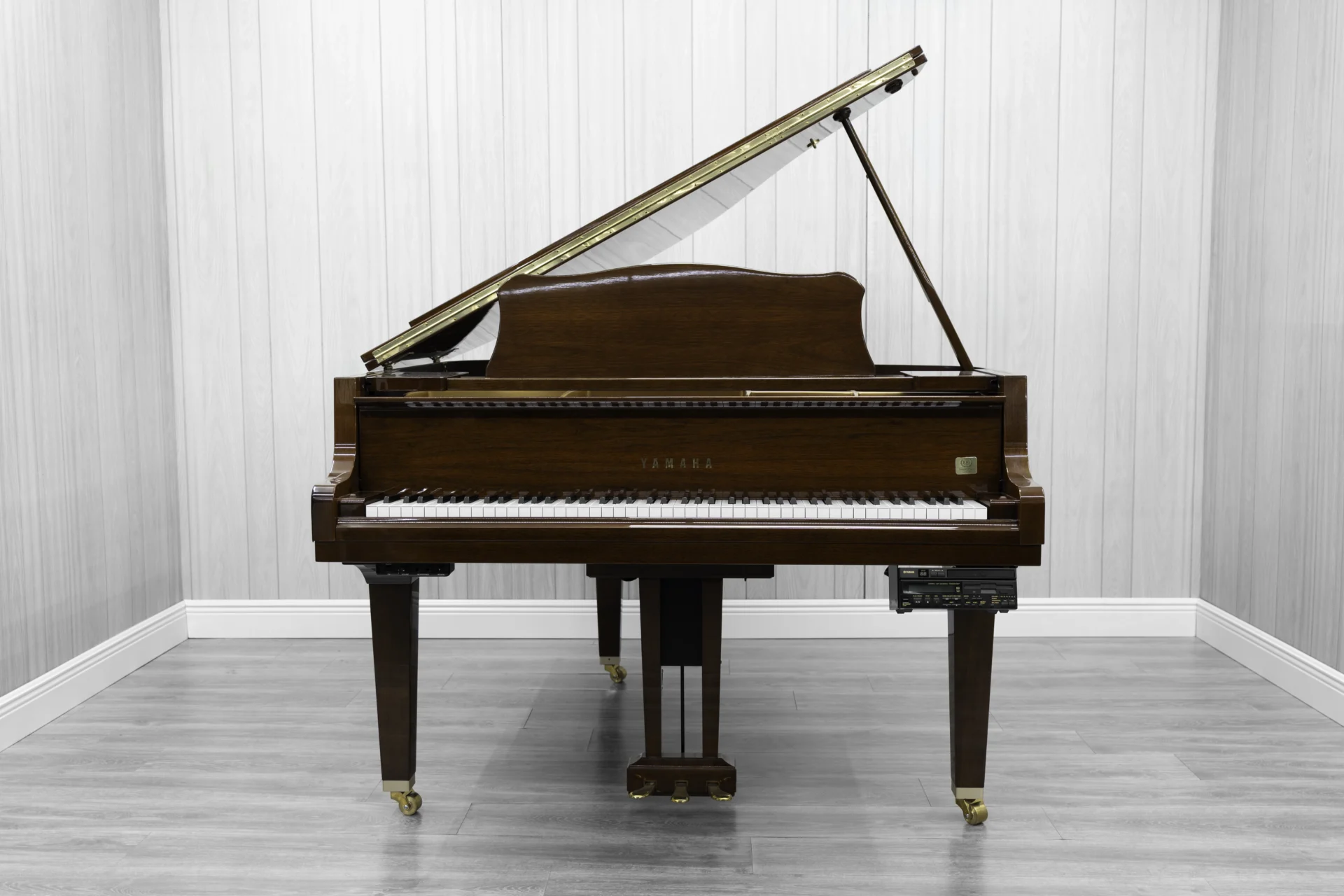 A pre-owned Yamaha GH1 baby grand piano in a beautiful mahogany finish with brass hardware.