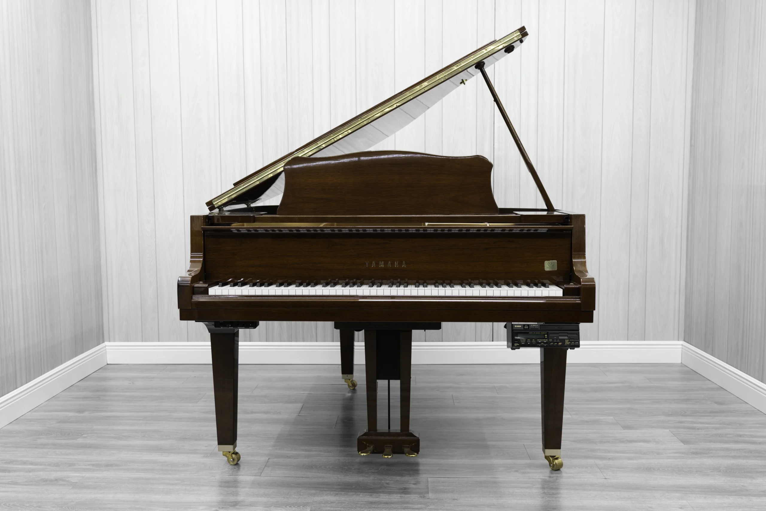 A pre-owned Yamaha GH1 baby grand piano in a beautiful mahogany finish with brass hardware.